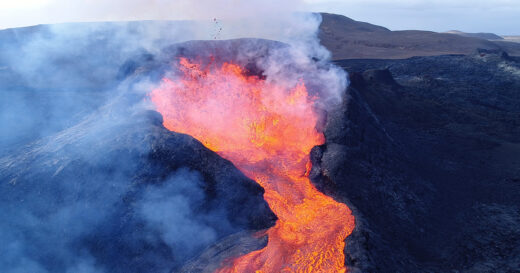 Lava bubbling out of the top of a volcano.