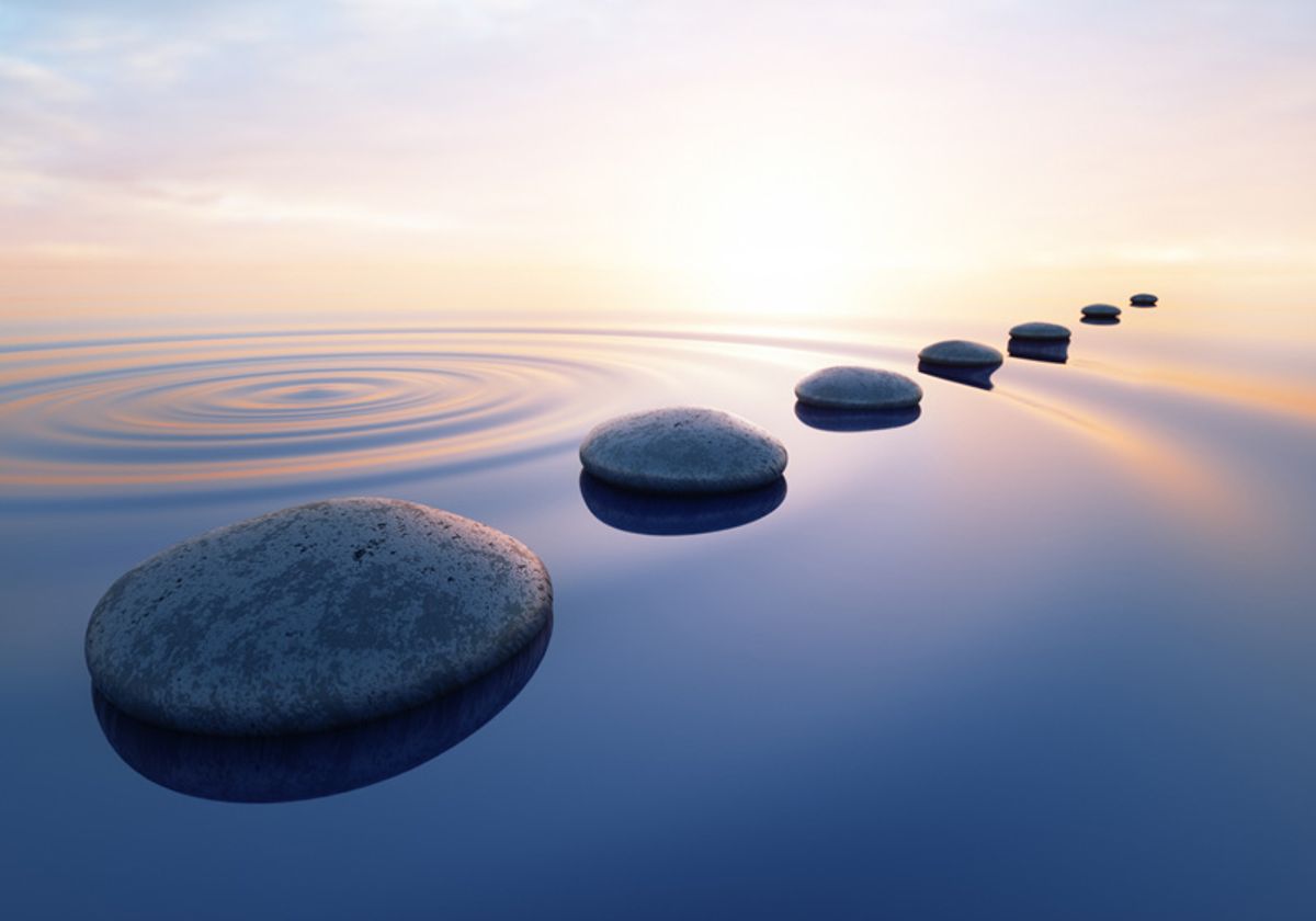 Row of stones floating on top of water with ripple