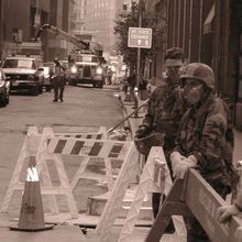 Two emergency responders stand near a barricade on a street in New York