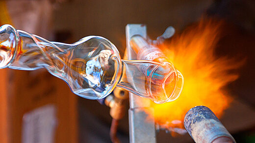 A glass object being shaped by a blowtorch.]