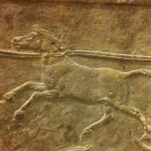 stone panel depicting a horselike animal led by ropes around the neck