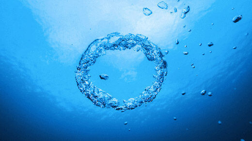 A ring of bubbles in blue water.