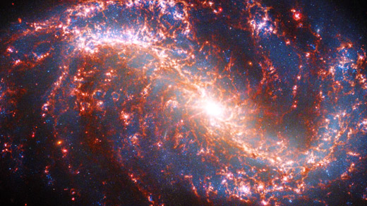 Image of a spiral galaxy strewn with ribbons of pink light.]