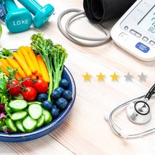a three star rating displays next to a bowl of fruits and vegetables with a stethoscope, scale, and other health and fitness supplies in the background.